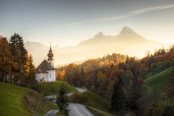 alpes de baviera, con puesta de sol brillante en la iglesia remoto - bavaria fotografías e imágenes de stock