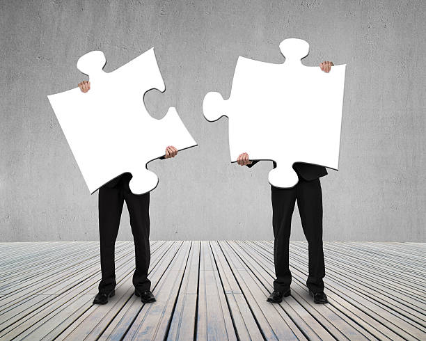 istock Businessmen holding two puzzles to connect 494543517