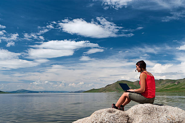 istock Young woman with laptop on the rock 494544925