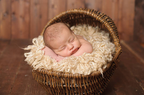 Sleeping Newborn Boy An adorable newborn boy sleeping peacefully. moses basket stock pictures, royalty-free photos & images