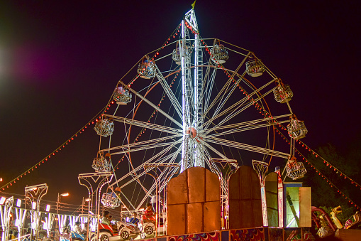 Howrah, India - March 1, 2015: A big ferris wheel (called Nagordoal locally) about to roll with people, at Howrah, West Bengal, India. This time of the year is full of festivities and celebrations.