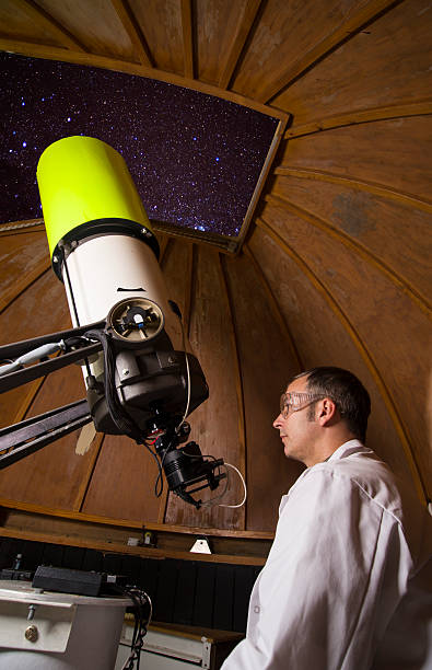 Looking up A male astronomer working on his telescope astronomer photos stock pictures, royalty-free photos & images