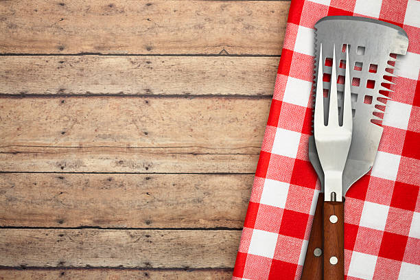 BBQ Utensils on Brown Rustic Picnic Table stock photo