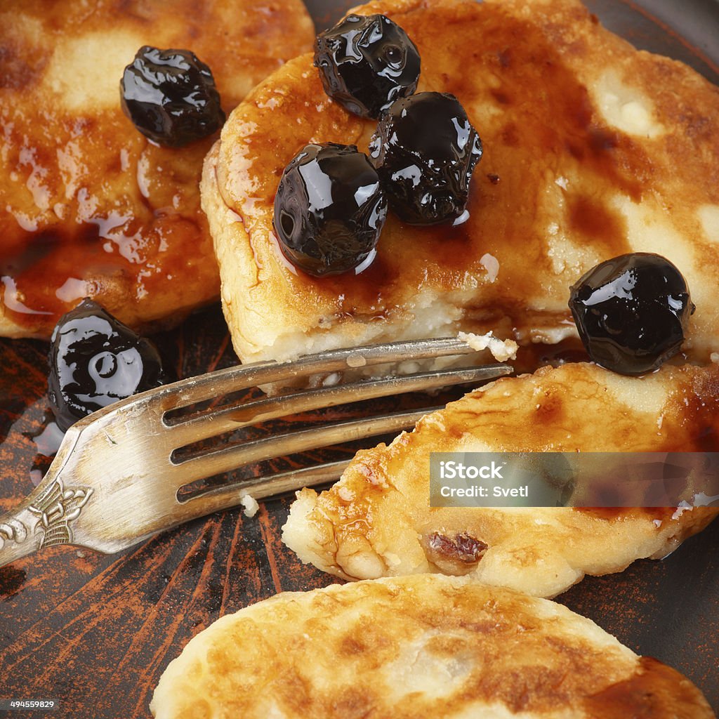 Cottage cheese pancakes Cottage cheese pancakes with cherry conserve on brown plate. Baked Stock Photo