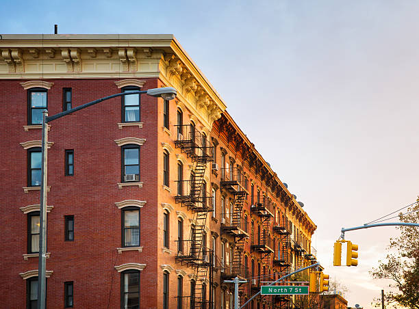 Brooklyn brownstone Apartment buildings at sunset panorama Brooklyn brownstone Apartment buildings at sunset panorama, shot at street level, on a corner. Street sign and traffic lights visible. 20th century style stock pictures, royalty-free photos & images