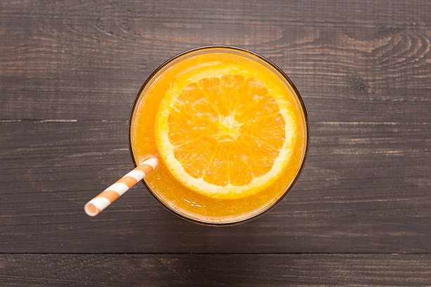 Fresh orange juice in glass on wooden background Fresh orange juice in glass on wooden background. fruit juice stock pictures, royalty-free photos & images