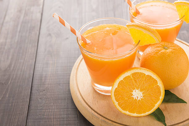 istock Fresh orange juice and oranges on wooden table 494562654