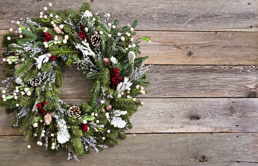 Christmas Wreath hung on barn board background. Copy space.