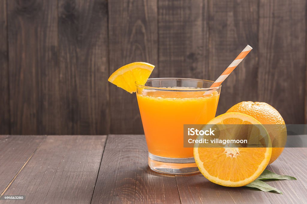 Jus d'orange frais et oranges sur table en bois - Photo de Table libre de droits