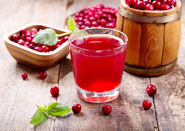 glas cranberry-saft mit frischen beeren - cranberry stock-fotos und bilder