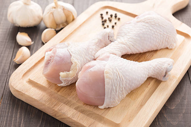 istock Ingredients and raw chicken drumsticks on cutting board on wood 494565898