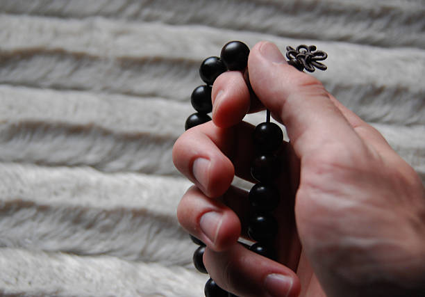 Praying with Mala Beads Man's hand with Buddhist rosary praying. shingon buddhism stock pictures, royalty-free photos & images