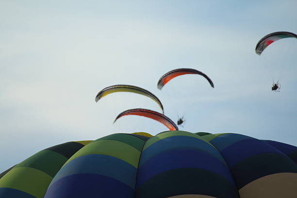 Paragliders make the spectacular perform between hot air balloons