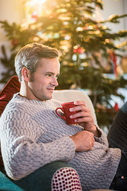 istock Christmas morning, man holding a cup near christmas tree 494568630