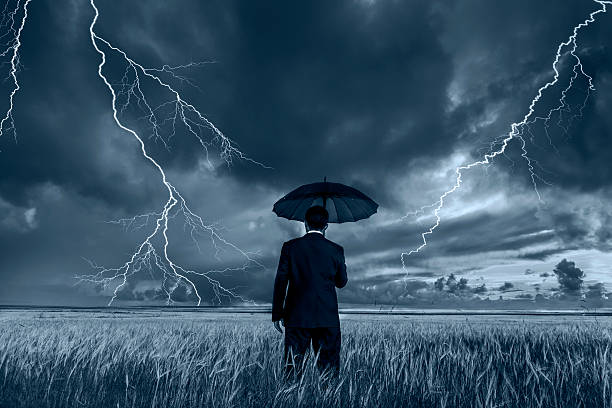 istock Man in black suit with a black umbrella in a storm 494569730