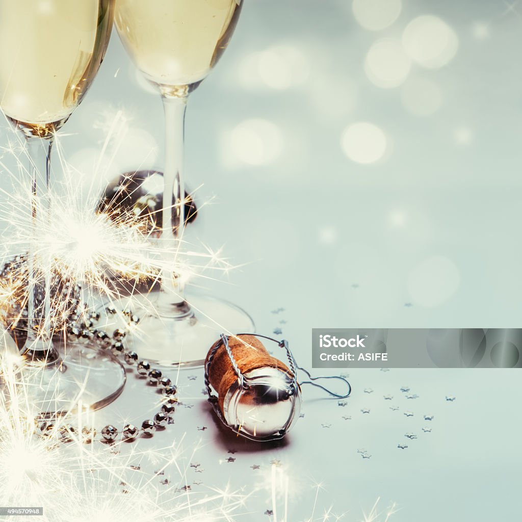 New year with champagne background Two champagne glasses and cork with baubles, sparklers, confetti and lights. Copy space. Cork - Stopper Stock Photo