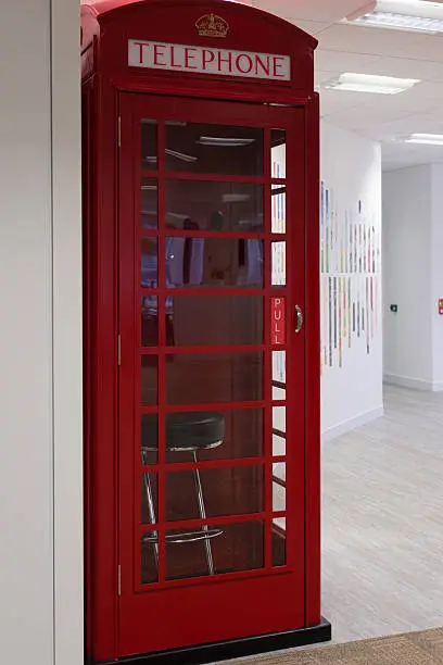 Iconic British telephone box in an office building.