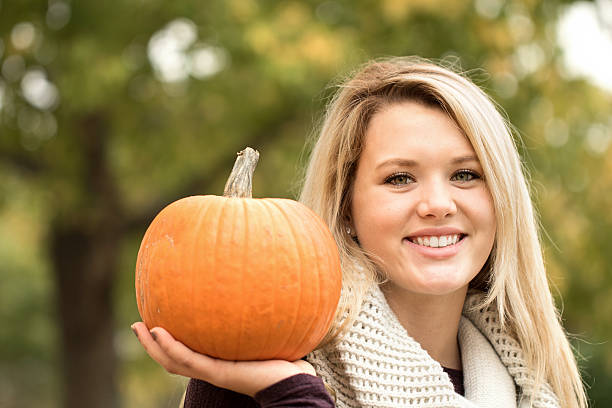 istock Young woman holding a pumpkin. 494571692