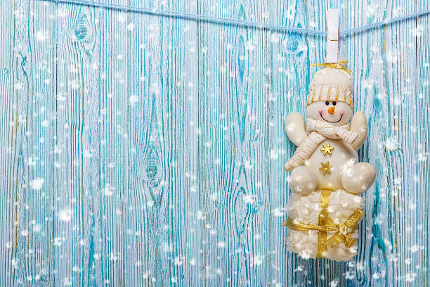 istock Christmas snowman hanging from a rope on a rustic background 494571726