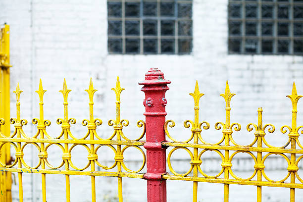 Old yellow fence with red pole in industrial area in Germany.