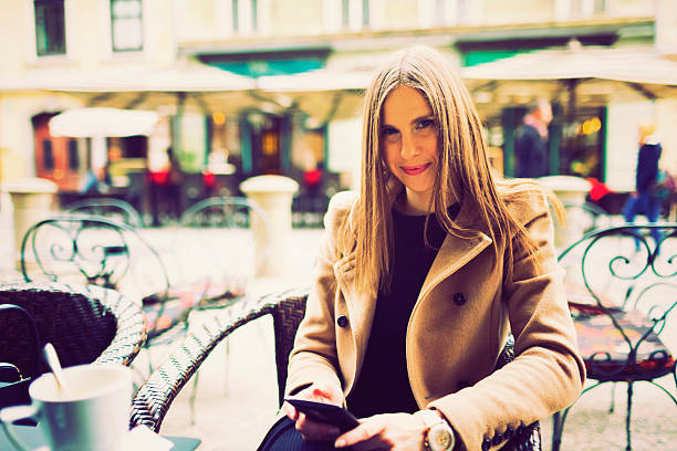 istock Young woman text messaging in outdoor cafe 494573164