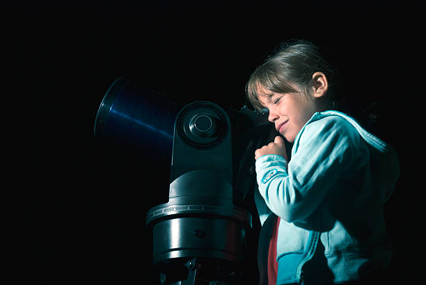 istock Child looking through telescope in the night 494583112