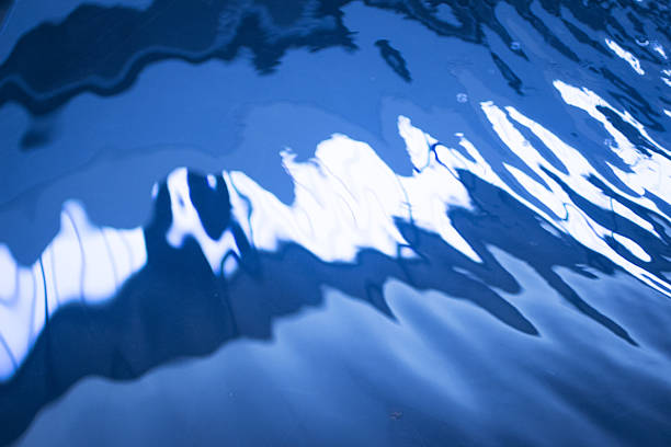 Colourful abstract background comprised of reflections of fishing boats in harbour water