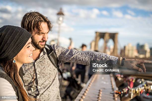 Couple Looking At New York City From Brooklyn Bridge Stock Photo - Download Image Now