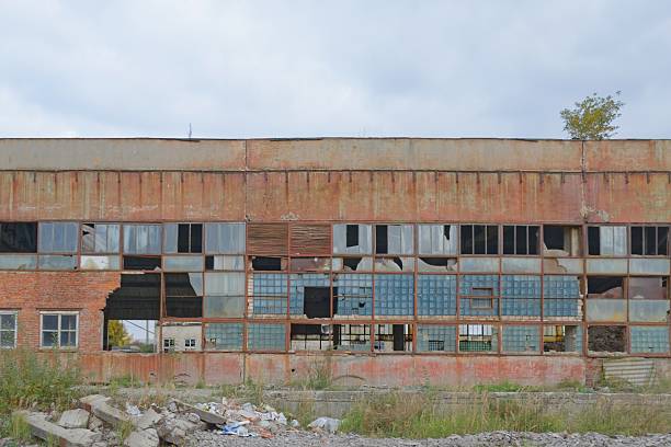 Urban decay series. Abandoned plant building exterior with broken windows