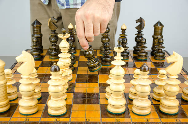 istock Man standing next to a game of chess table 494584862