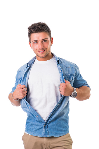 Handsome young man opening shirt on chest like a superhero, isolated on white background