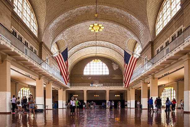 New York City, New York, USA - August 19, 2015:  View of the Great Hall at historic landmark Ellis Island immigrant gateway with people visible.  This notable tourist attraction was the gateway for millions of immigrants to the United States as the nation's busiest immigrant inspection station from 1892 until 1954.