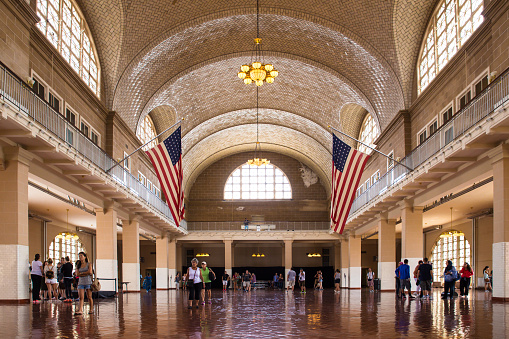 New York City, New York, USA - August 19, 2015:  View of the Great Hall at historic landmark Ellis Island immigrant gateway with people visible.  This notable tourist attraction was the gateway for millions of immigrants to the United States as the nation's busiest immigrant inspection station from 1892 until 1954.