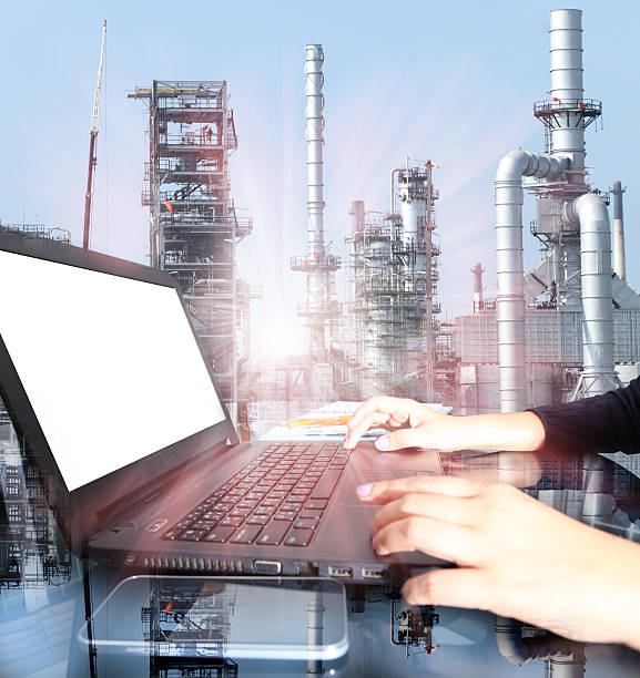 istock hand working on  laptop computer with oil refinery industry 494588602