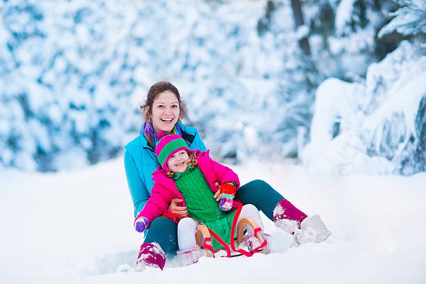 istock Mother and child sledding in a snowy park 494588796
