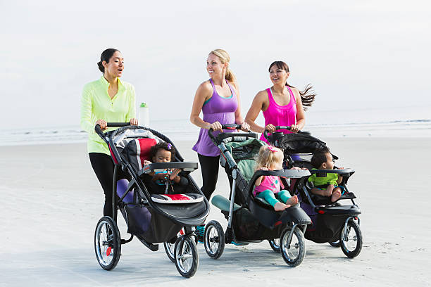 istock Three mothers and babies in strollers walking on beach 494590080