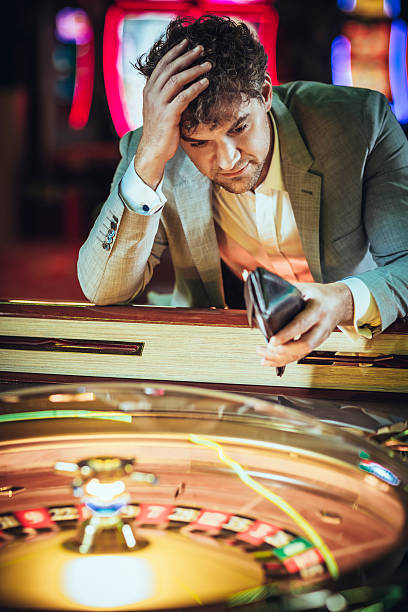 Male gambler losing at electronic roulette in  casino stock photo