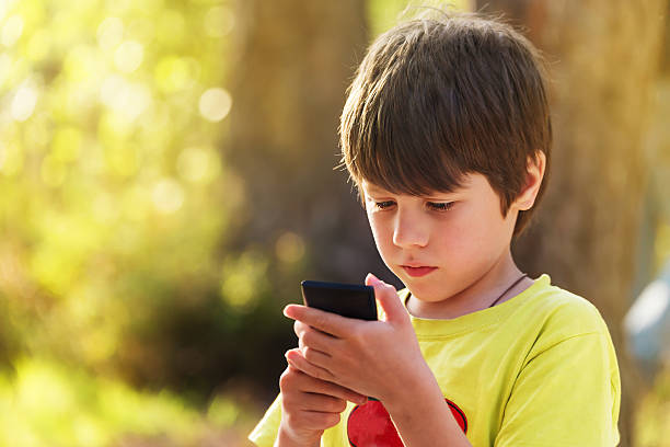 istock Child playing mobile phone outdoors 494594480
