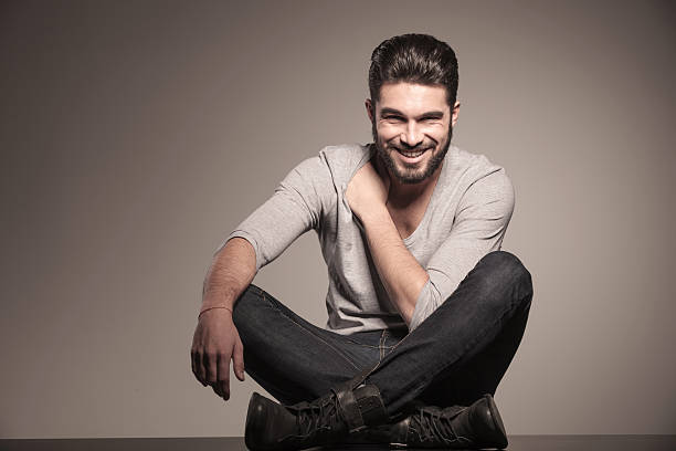 istock smiling fashion man sits on the floor 494597335