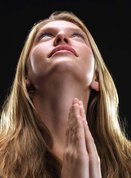 istock blonde young woman praying 494597339