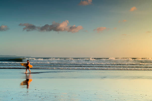 surfista com teclado caminhando na praia - kuta beach - fotografias e filmes do acervo