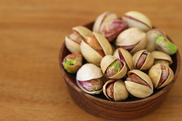 istock Pistachios in wooden bowl, close up 494597481