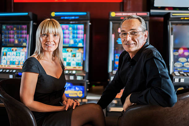 Smiling mature couple enjoying in a casino and looking at the camera.   