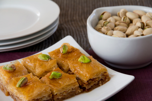 Piece of delicious baklava with pistachios isolated on white.