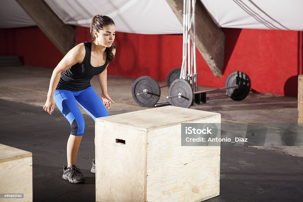 Ready to jump in a gym gym Cute athletic brunette doing some jumping exercises in a cross-training gym Active Lifestyle Stock Photo