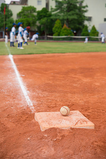 istock baseball and base on baseball field with players on background 494604730