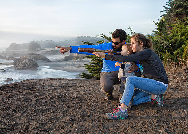 istock Family with spyglass looking toward ocean 494604936
