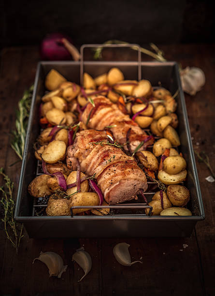 getting ready for pork tenderloin roast with potatoes, onions, carrots and herbs
