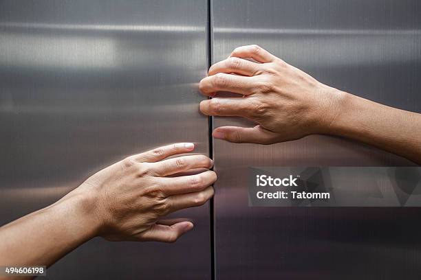 Woman Hands Try To Stop Doors Of The Closed Elevator Stock Photo - Download Image Now