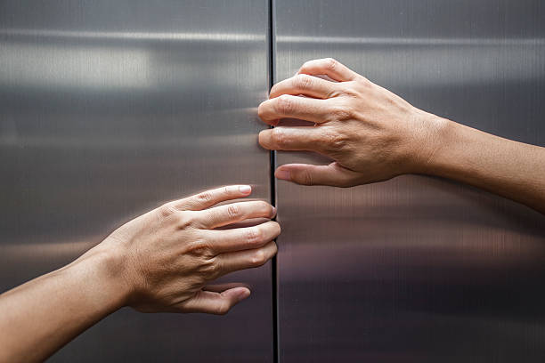 женщина руками, чтобы остановить двери закрытые лифт - claustrophobic стоковые фото и изображения
